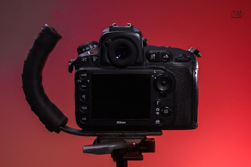 Back facing DSLR Camera attached to a Camera Handle mounted on a tripod