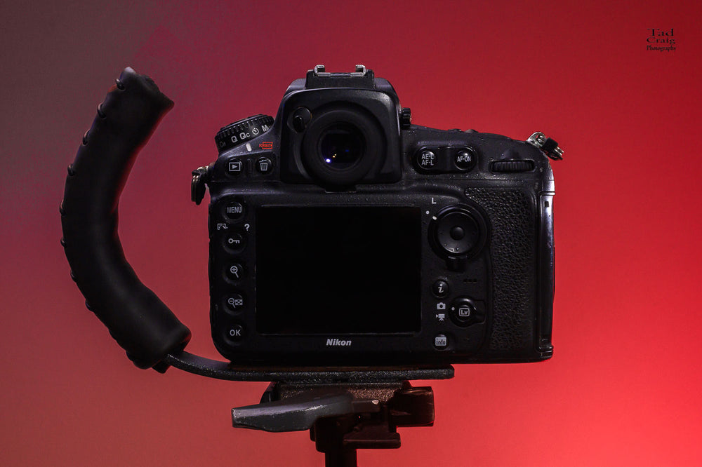 Brown Leather Camera Handle on DSLR Camera with a grip attached mounted to a tripod 