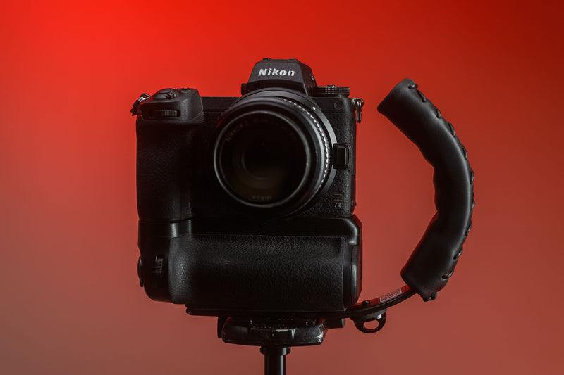 Black Leather Camera Handle on Mirrorless Camera with a grip attached mounted to a tripod 
