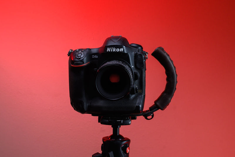 Brown Leather Camera Handle on DSLR Camera with a grip attached mounted to a tripod 