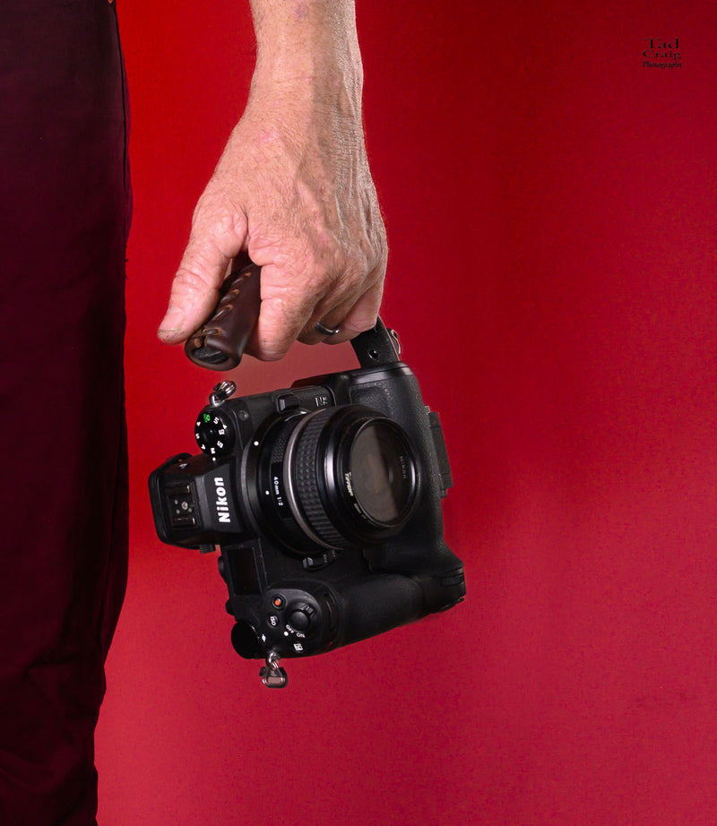 Hand Holding Camera Handle attached to a mirrorless camera 